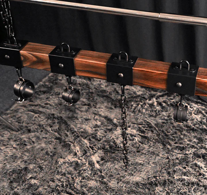Elm wood spreader bar shown with three cuffs along the carbonized elm bar - BDSM Authority