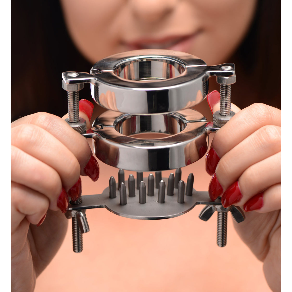 Steel dual-ring ball stretcher held in hands to show its scale - BDSM Authority