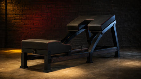 Premium padded breeding bench in a dark editorial playroom BDSMAuthority