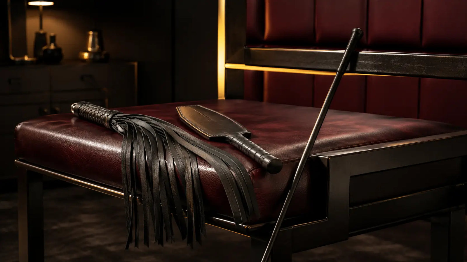 Impact play tools and spanking bench in a dark premium playroom BDSMAuthority