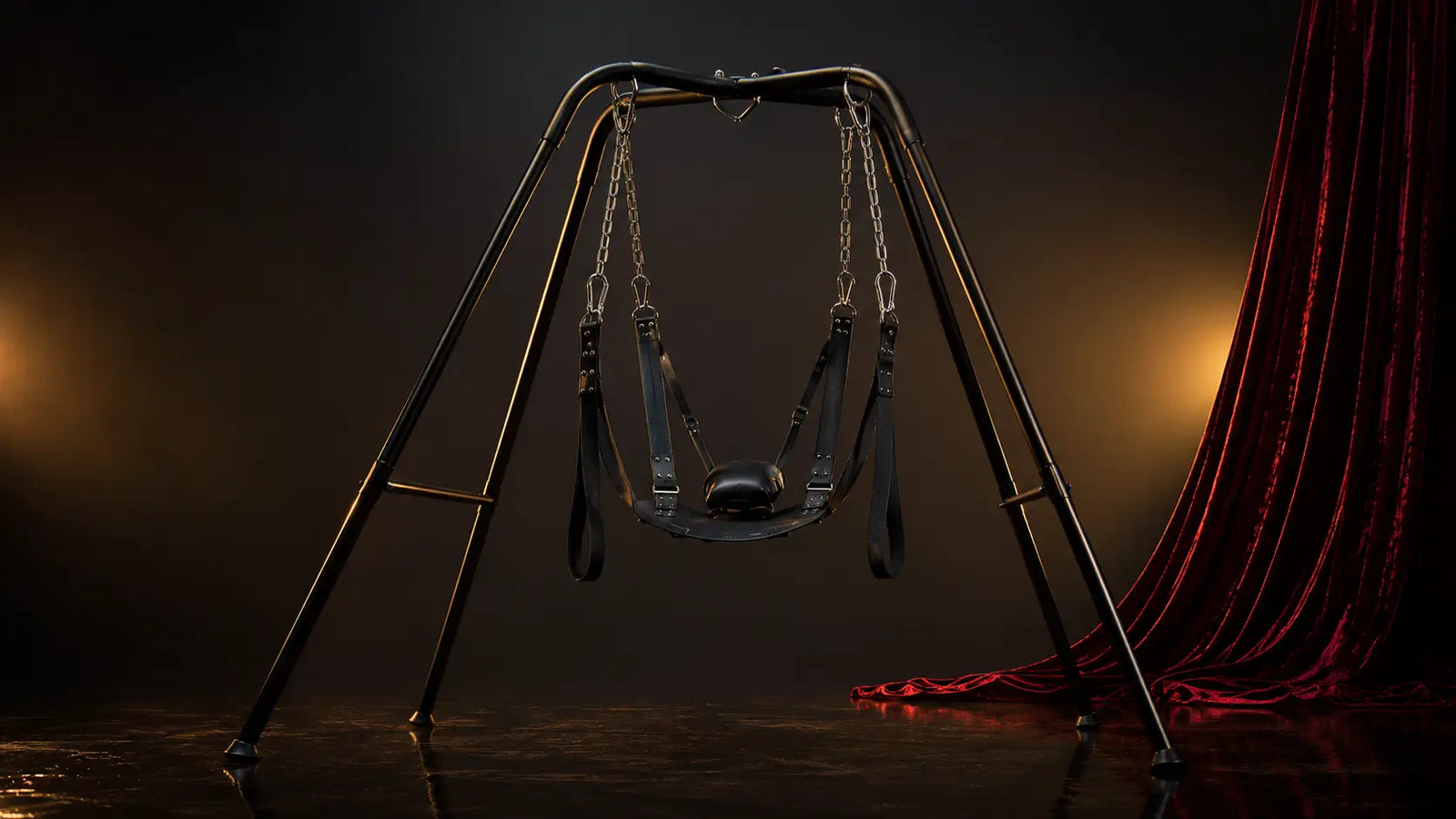 Premium sex swing on a freestanding steel stand in a dark editorial studio BDSMAuthority