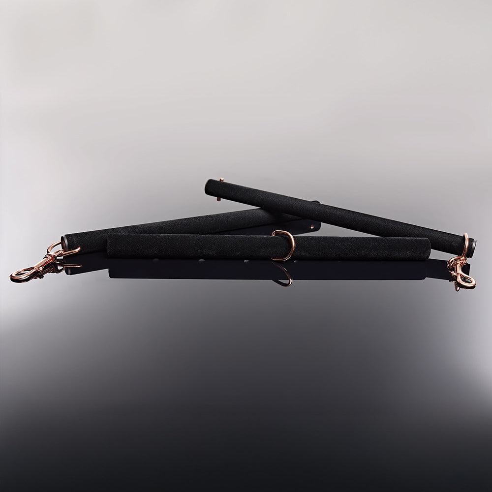 Coquette Pleasure spreader bar showing the adjustable sliding length mechanism - BDSM Authority