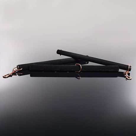 Coquette Pleasure spreader bar showing the adjustable sliding length mechanism - BDSM Authority