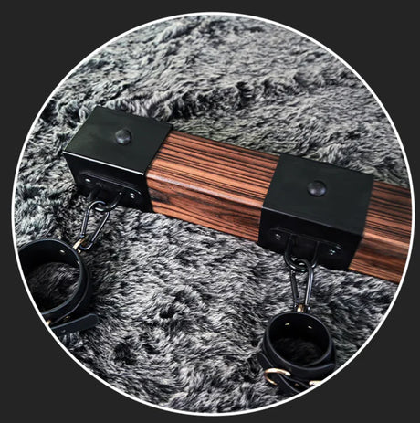 Elm wood spreader bar shown with two cuffs along the carbonized elm bar - BDSM Authority