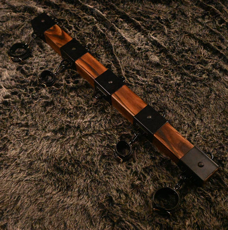 Elm wood spreader bar point-of-view angle showing cuffs and steel hardware for positioning - BDSM Authority