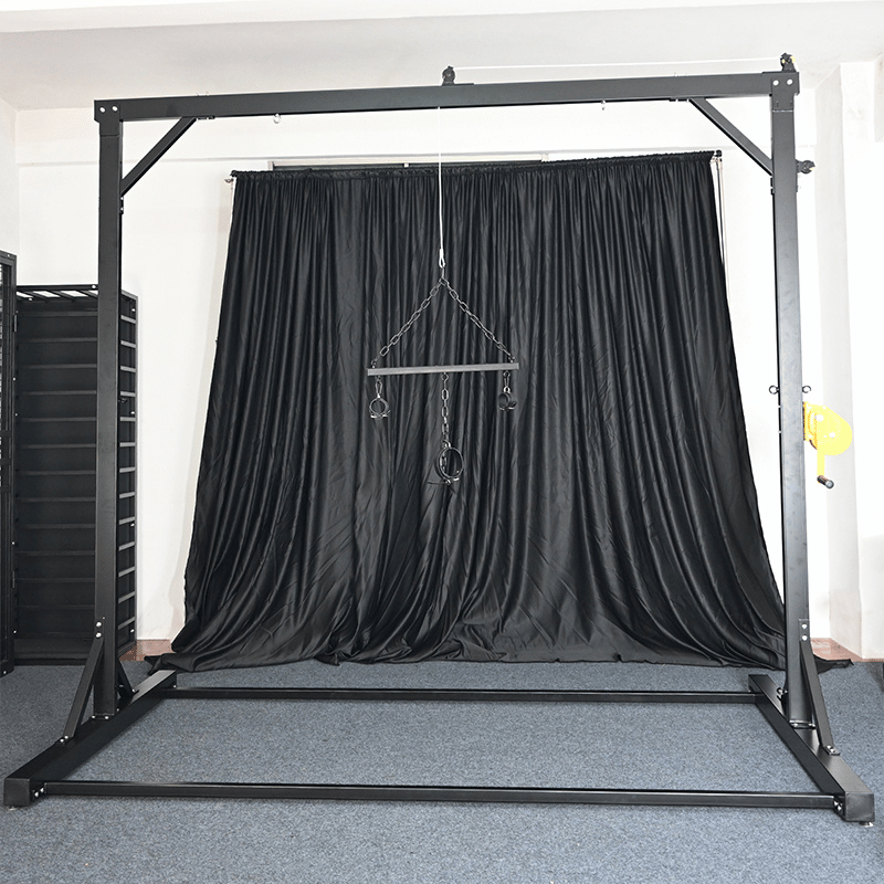 Studio gantry rack side view with reinforced steel uprights and adjustable suspension points, BDSM Authority