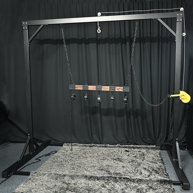 Studio gantry bondage frame front view showing overhead beam and integrated suspension hardware, BDSM Authority