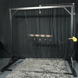 Studio gantry bondage frame front view showing overhead beam and integrated suspension hardware, BDSM Authority