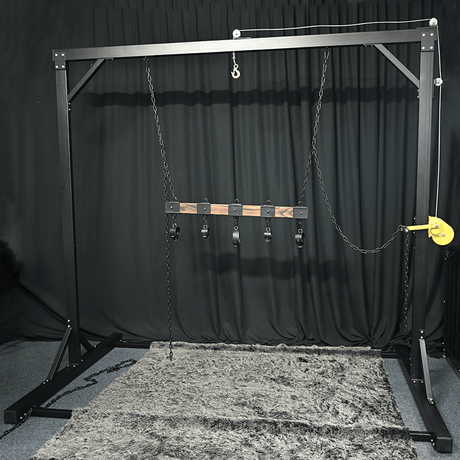 Studio gantry bondage frame front view showing overhead beam and integrated suspension hardware, BDSM Authority