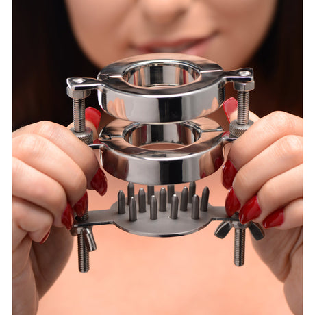 Steel dual-ring ball stretcher held in hands to show its scale - BDSM Authority