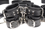 Leather bed restraint cuffs and connector straps laid out - BDSM Authority