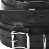 Close detail of the leather thigh cuff buckle and hardware - BDSM Authority