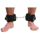 Padded leather ankle restraints worn on a model's ankles - BDSM Authority